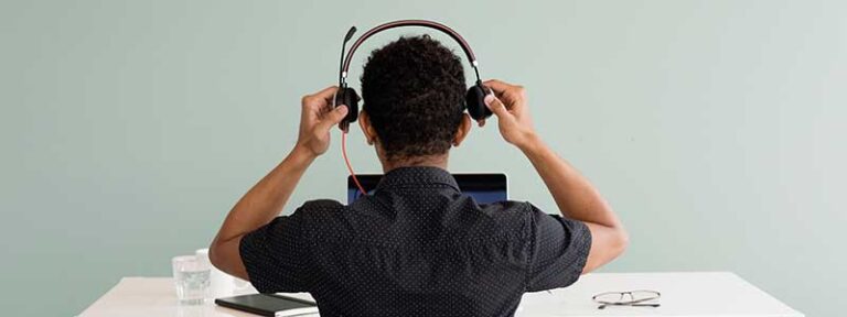 man putting on headset in front of computer ready for customer support call