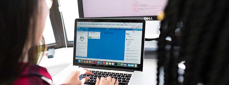 two women in tech look at computer and tools to manage compliance