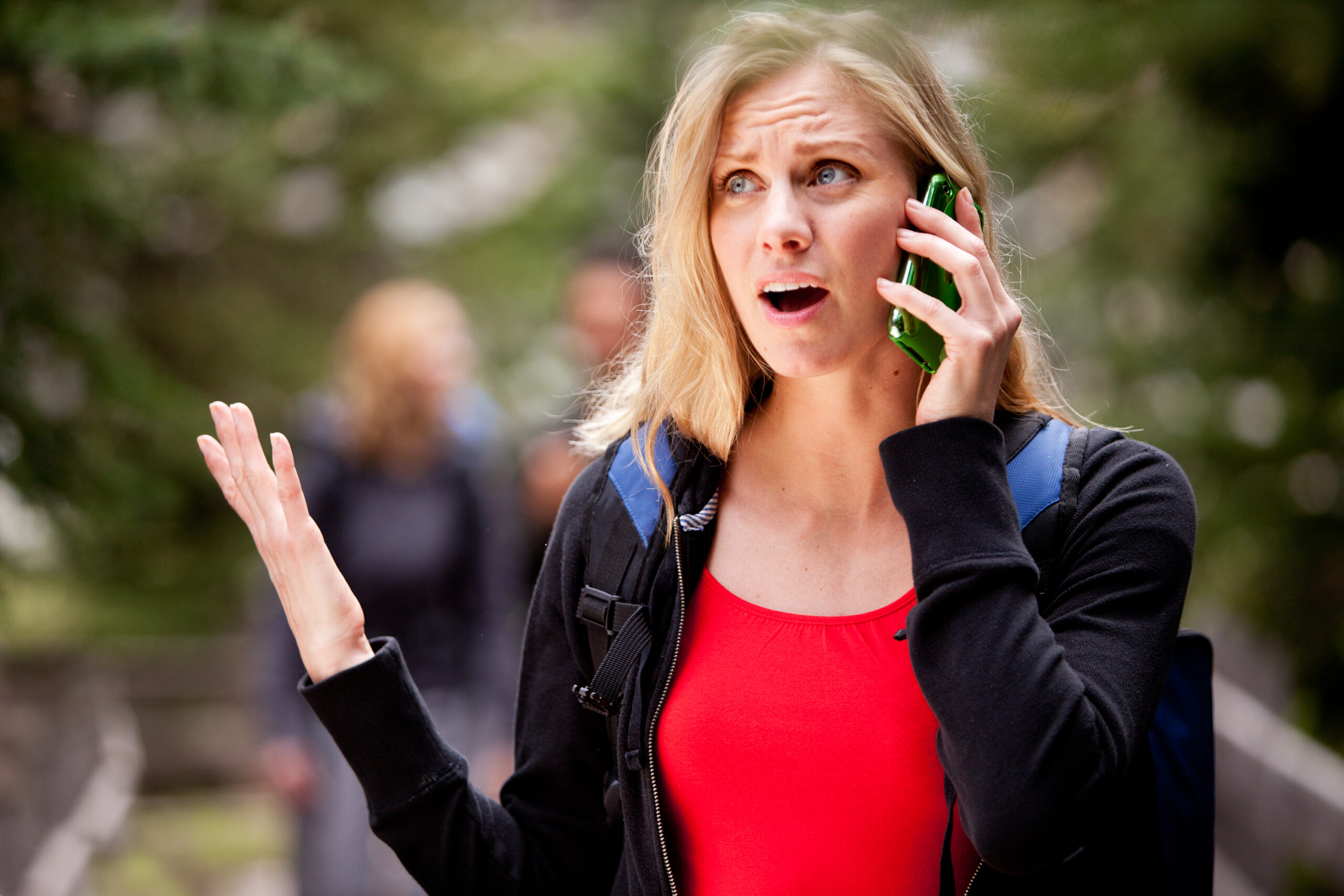 A woman talking on the phone, frustrated with the person she is talking to
